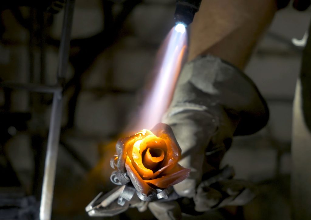 a branding iron being heated using a torch