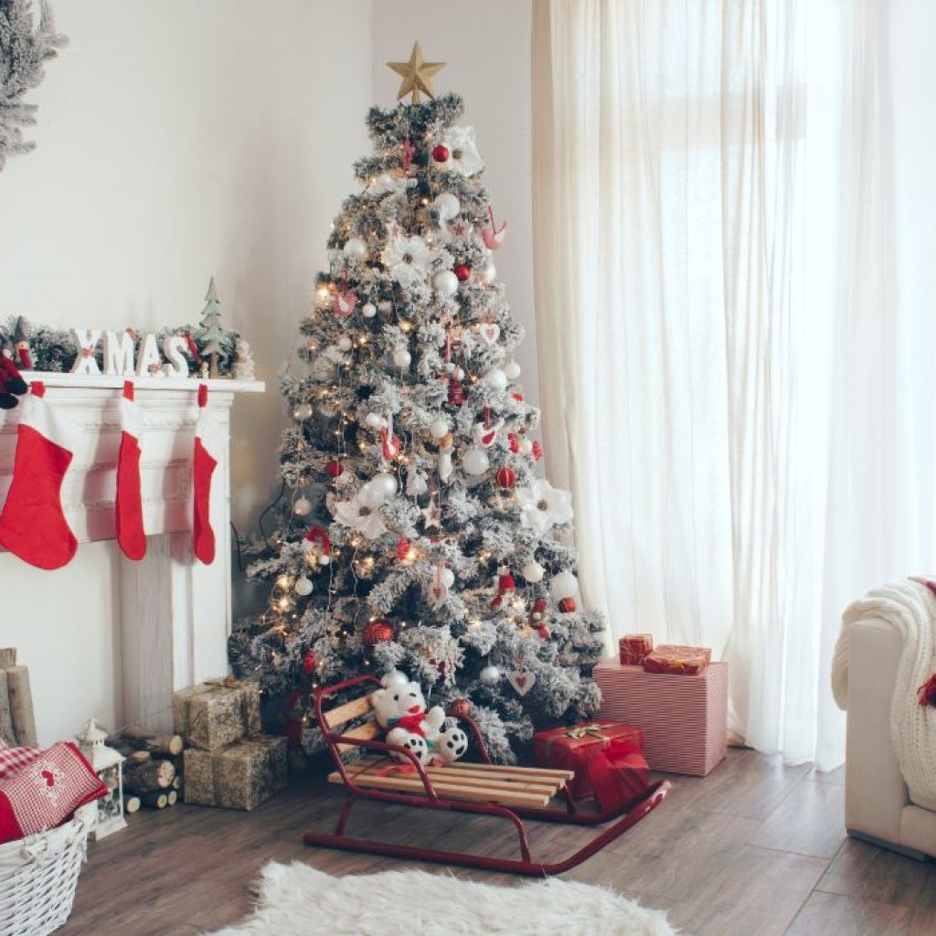 An image of a flocked Christmas tree within a living room. 