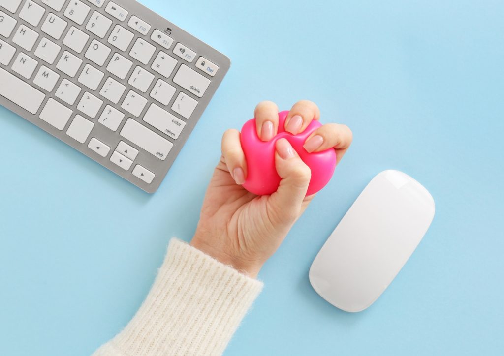 a womans hand squeezing a stress ball