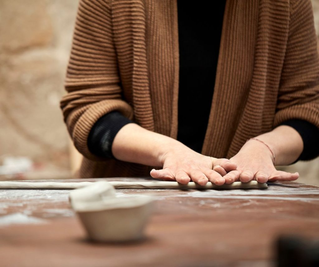 Coiling is a flexible pottery method that uses lengthy, serpent-shaped clay pieces to construct structures through layering.