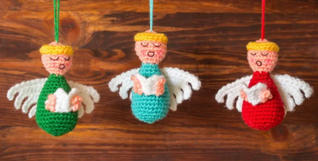 An image of three angelic Christmas yarn crafts.