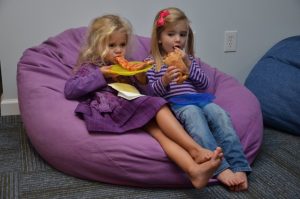 An image of kids eating on a bean bag for an article about "DIY bean bag chair."