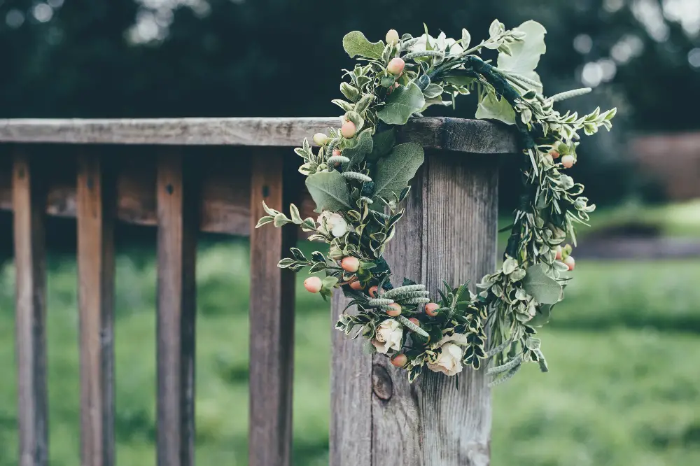 An image of a winter wreath hanged on a fence.