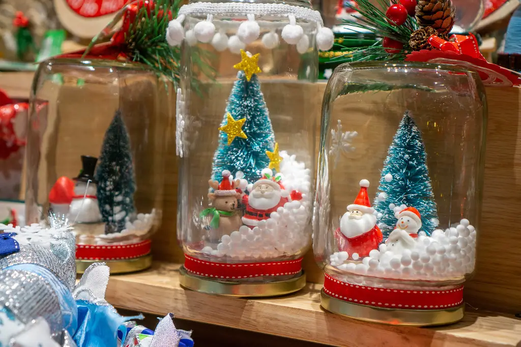 An image of holiday decorations inside three jars.