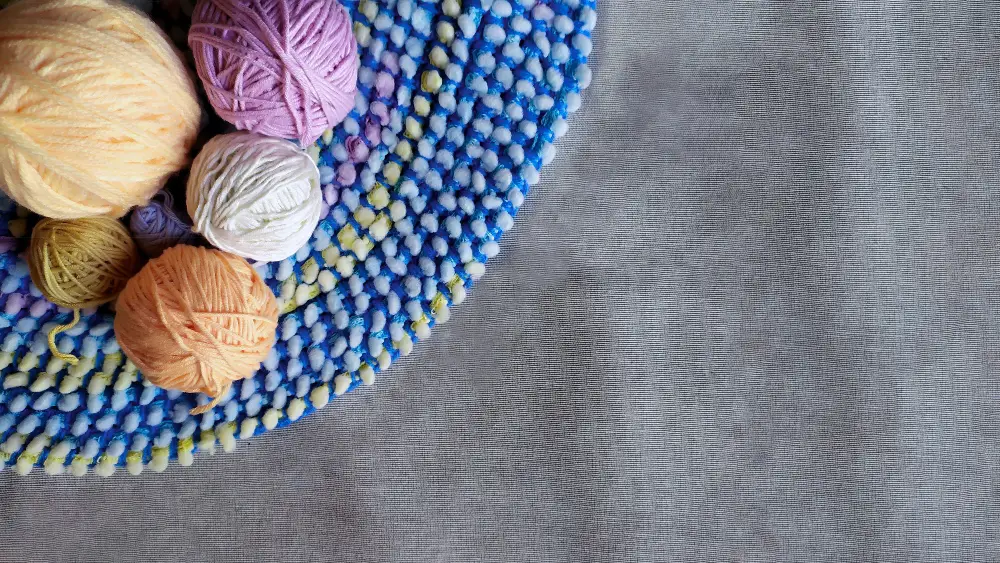 An image of yarns and a crocheted table cloth.