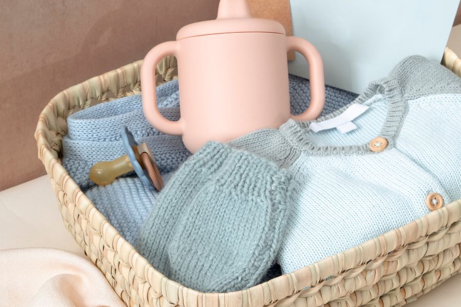 An image of baby gifts within a basket. 